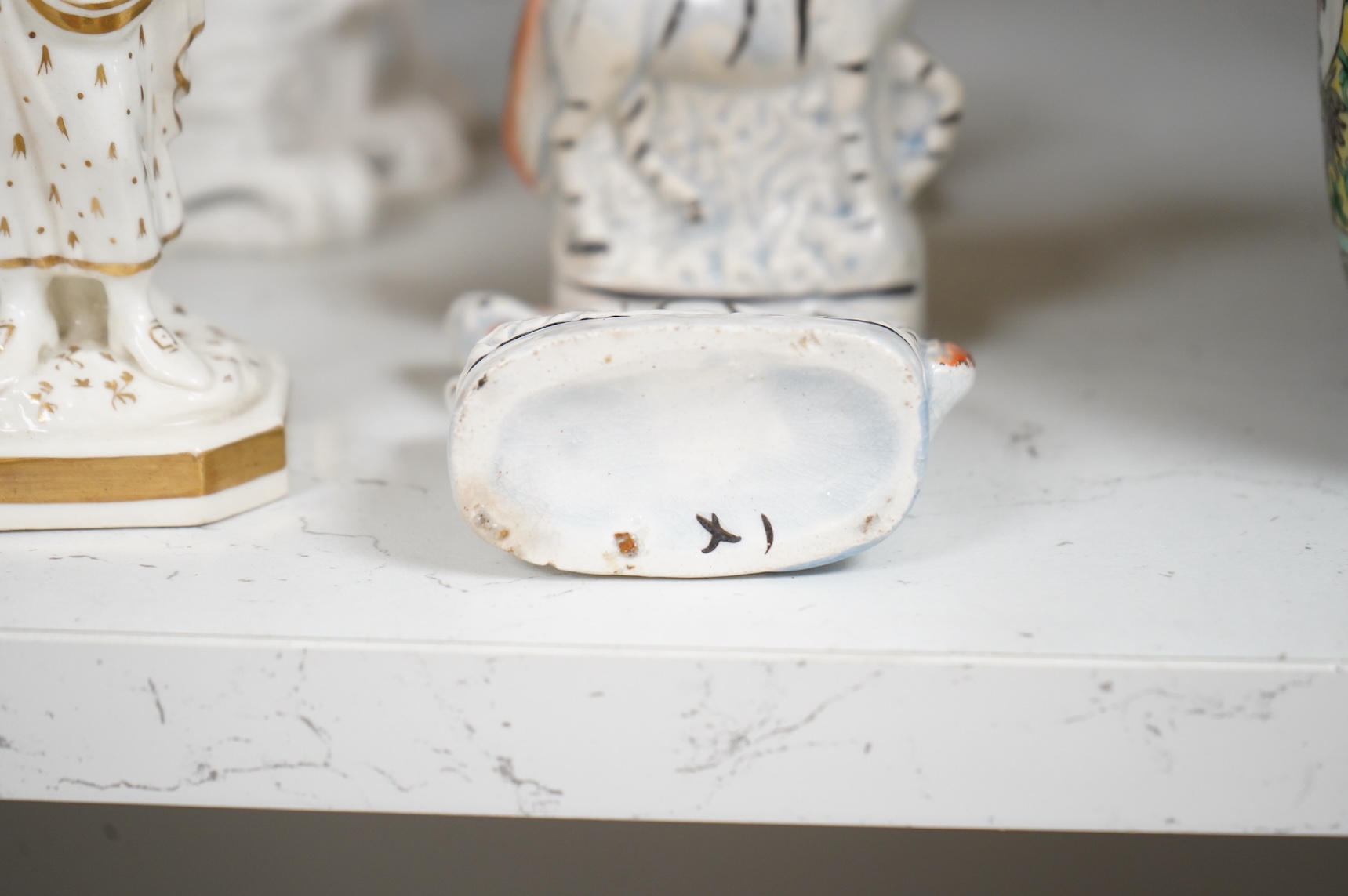 A group of mid-19th century Staffordshire porcelain figures, two models of zebras and a early 19th century Derby biscuit porcelain figure of a seated lady, largest 18cm high